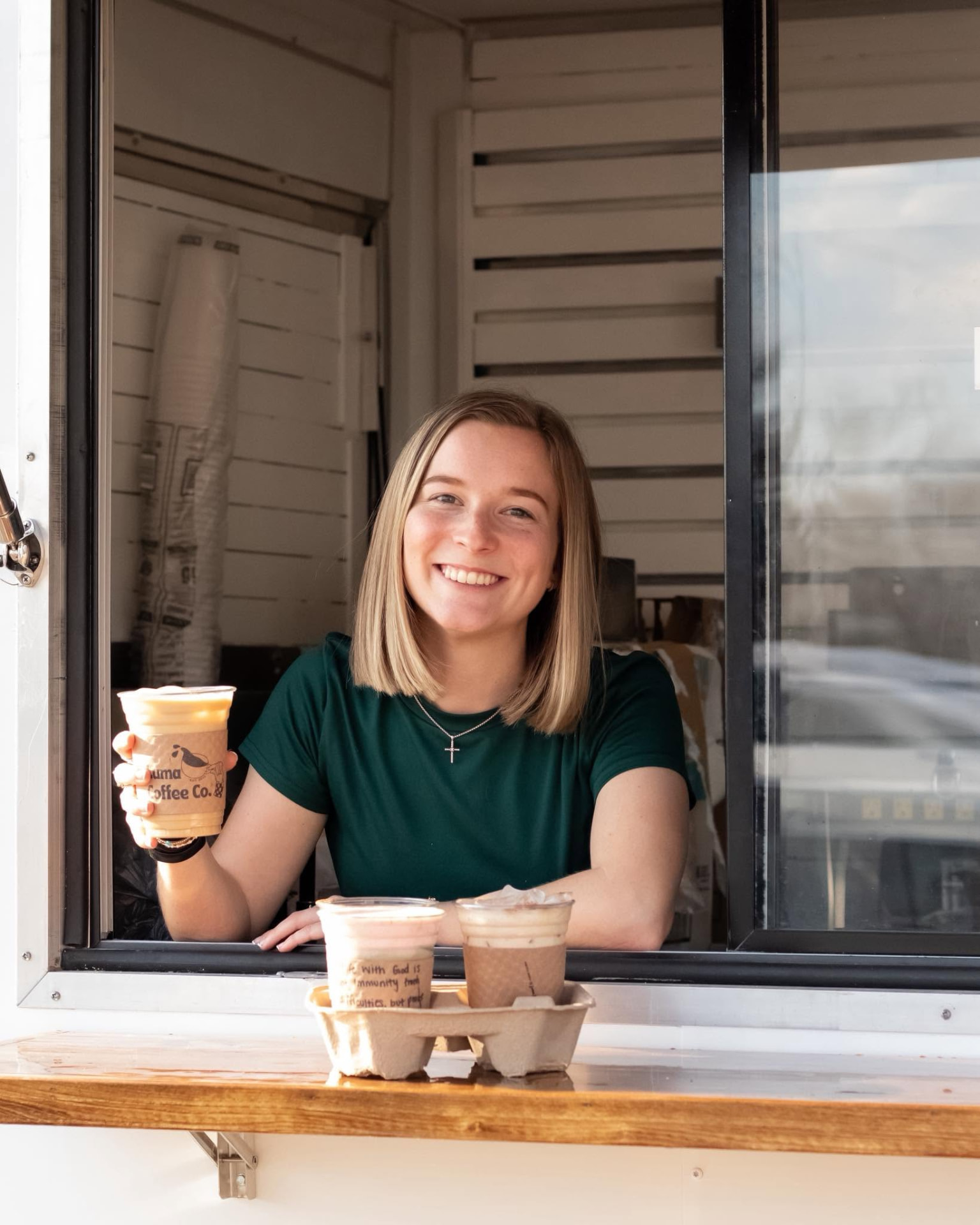 A Luma Coffee Co. barista handing drinks out of the trailer window